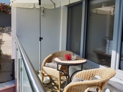 Sonniger Balkon mit zwei Stühlen und Sonnenschirm in der Ferienwohnung Margarethe in Velden am Wörthersee